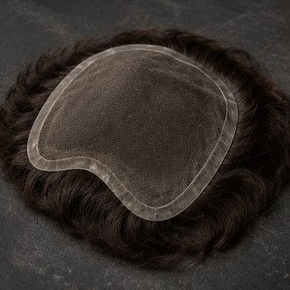 A men's hair system lying face up, the thin lace base visible against dark brown hair.